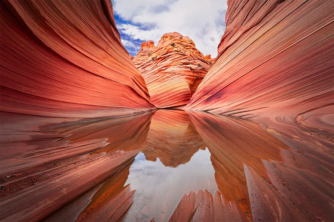Wave Reflections I | The Wave, Coyote Buttes North, Arizona | August 2025 Colorful slot canyon with red and orange rock formations and a reflective water pool.
